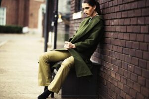 fashion-femme-brune-dans-la-rue-habillée-avec-un-manteau-et-un-pantalon-vert